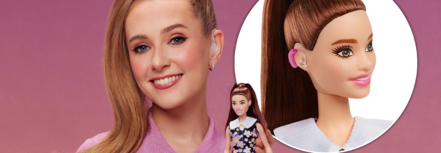 fundo rosê degradê, à esquerda a atriz loira cabelo preso no alto segurando o novo modelo da boneca barbie surda, à direita a foto ampliada do rosto da boneca destacando o aparelho auditivo.